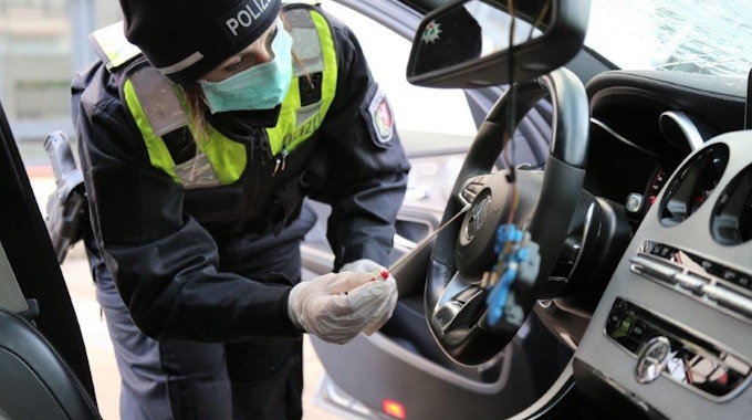Eine Polizistin sichert Spuren im mutmaßlichen Unfallfahrzeug von Deutz.