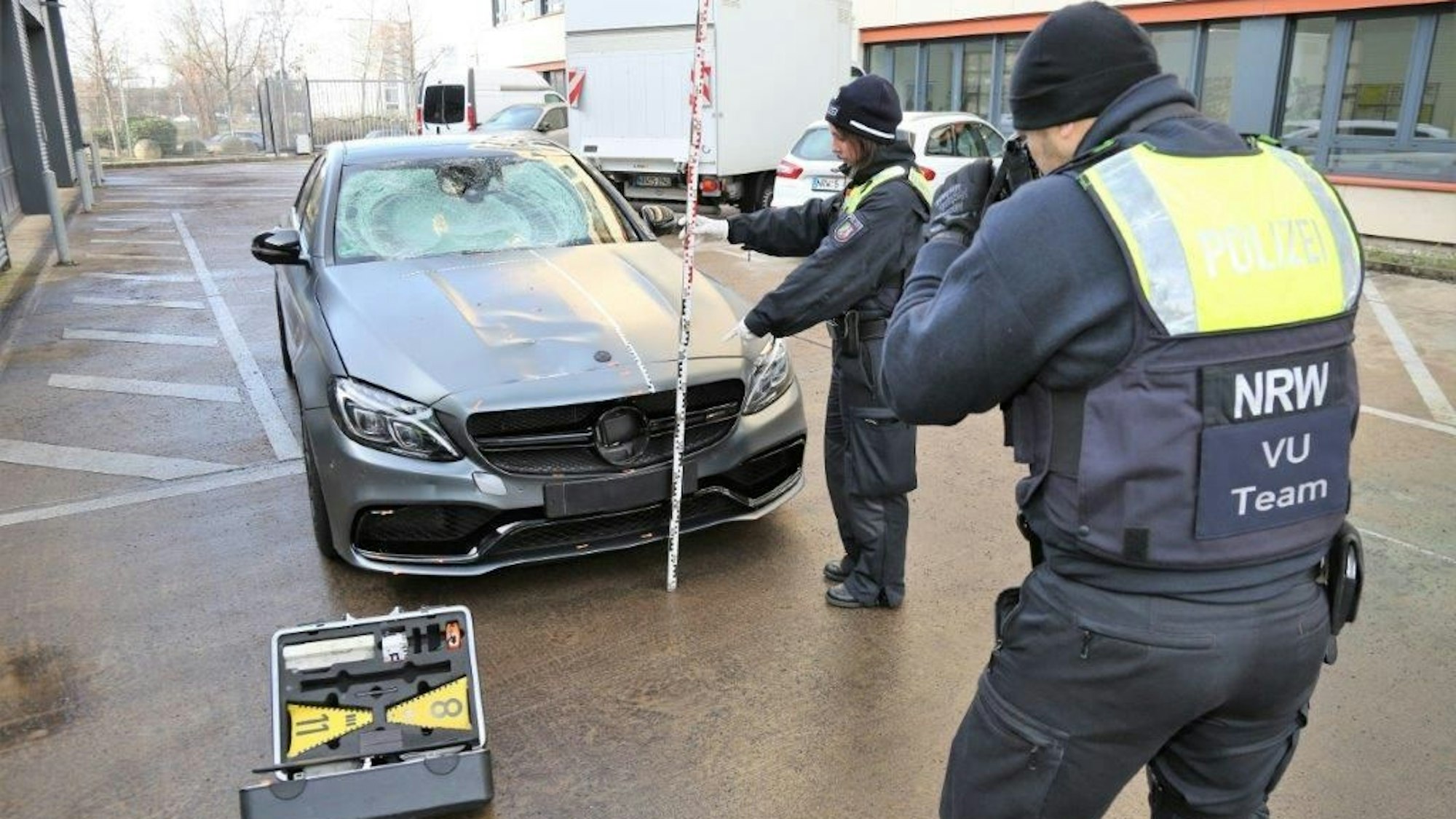 Mit einem Zollstock vermessen Polizisten den sichergestellten Mercedes AMG nach dem tödlichen Unfall in Köln-Deutz am 7. Januar
