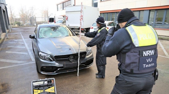 Mit einem Zollstock vermessen Polizisten den sichergestellten Mercedes AMG nach dem tödlichen Unfall in Köln-Deutz am 7. Januar