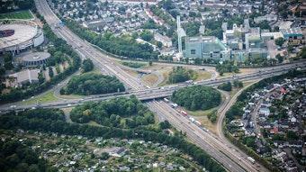 Luftbild des Autobahnkreuz Leverkusen mit A1 und A3. Am linken Bildrand ist die Bayarena zu sehen, abseits der anderen Straßen befinden sich Wohngebiete.