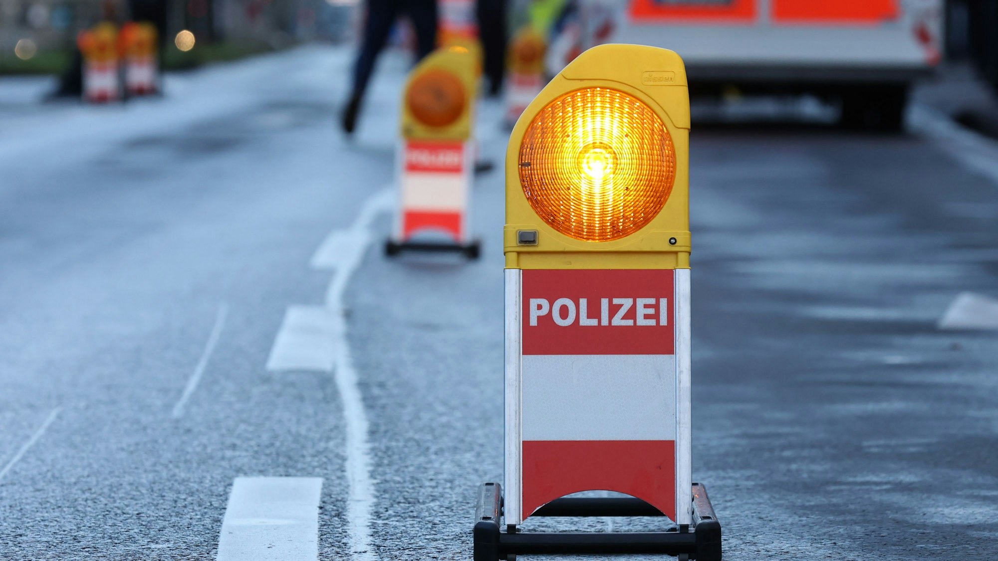 Eine Polizei-Warnbake steht auf einer Straße.