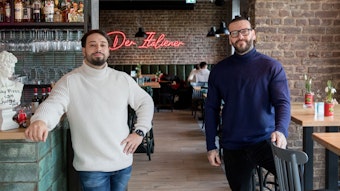 Nermin Music (links) und Marco Baron stehen in ihrem Restaurant, im Hintergrund sieht man an der Backsteinwand einen Neon-LED-Schriftzug mit "Der Italiener".