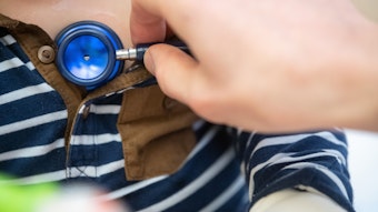 Ein Kinderarzt untersucht ein Kleinkind mit einem Stethoskop und hört ihm die Brust ab.