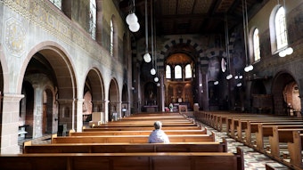 Eine Frau sitzt alleine in der Kirche St. Laurentius in Bergisch Gladbach.