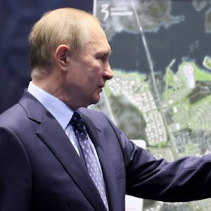 Wladimir Putin zeigt mit dem Finger auf eine Landkarte.