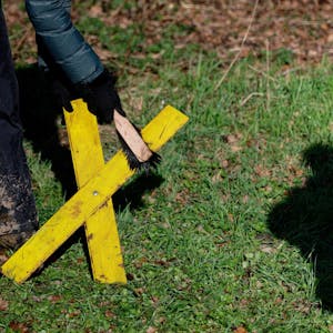 Eine Aktivistin reinigt in Lützerath in Keyenberg ein Gelbes Kreuz.