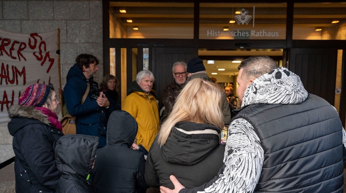 Die von der Räumung betroffene Familie steht vor dem Eingang des Kölner Rathauses.