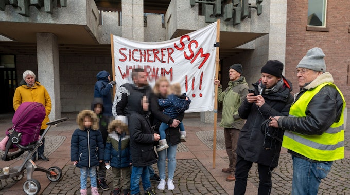 Familie W. steht während einer Protestkundgebung vor dem Kölner Rathaus.