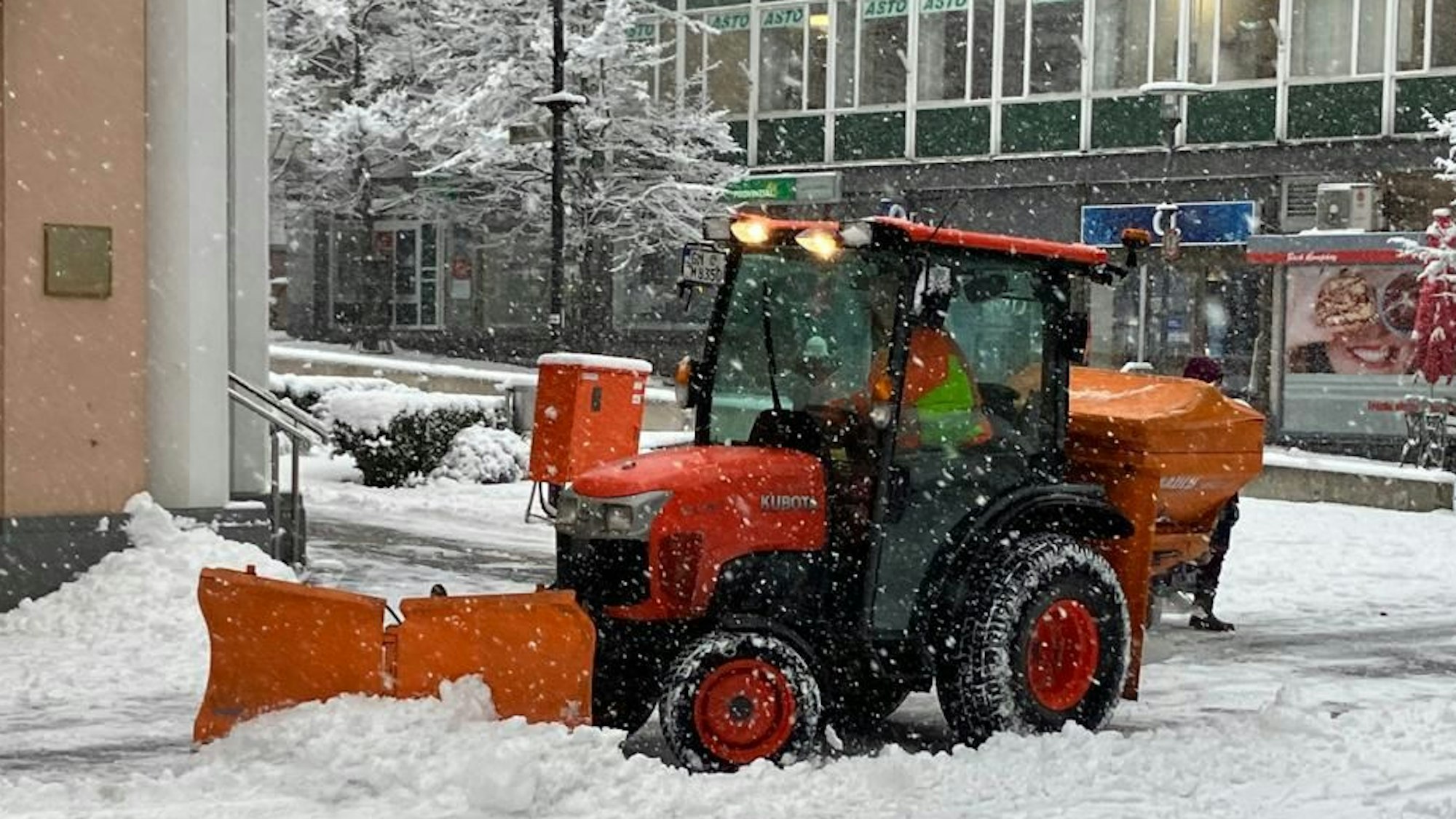 Ein Traktor mit einem Schneepflug räumt eine Straße in Gummersbach.