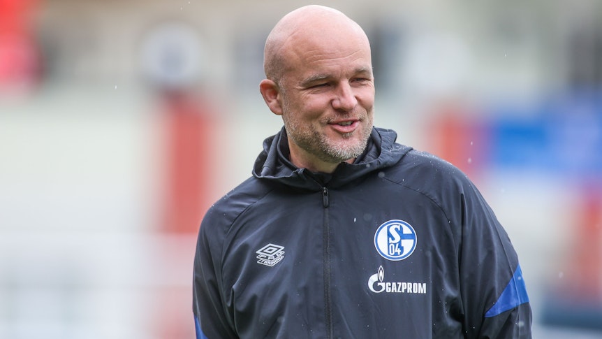 Schalkes Sportdirektor Rouven Schröder lacht auf dem Trainingsplatz.