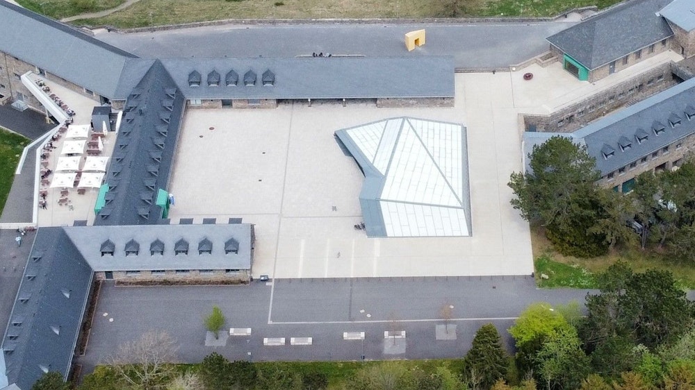 Blick aus der Luft auf das Besucherzentrum im Adlerhof mit der Glaskonstruktion, dessen Dach undicht ist.