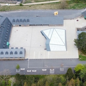 Blick aus der Luft auf das Besucherzentrum im Adlerhof mit der Glaskonstruktion, dessen Dach undicht ist.