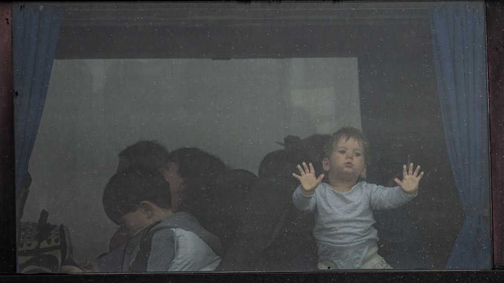Ein Kind steht im Fenster eines Busses, der am Grenzübergang Porubne in der Westukraine auf die Überfahrt nach Rumänien wartet.