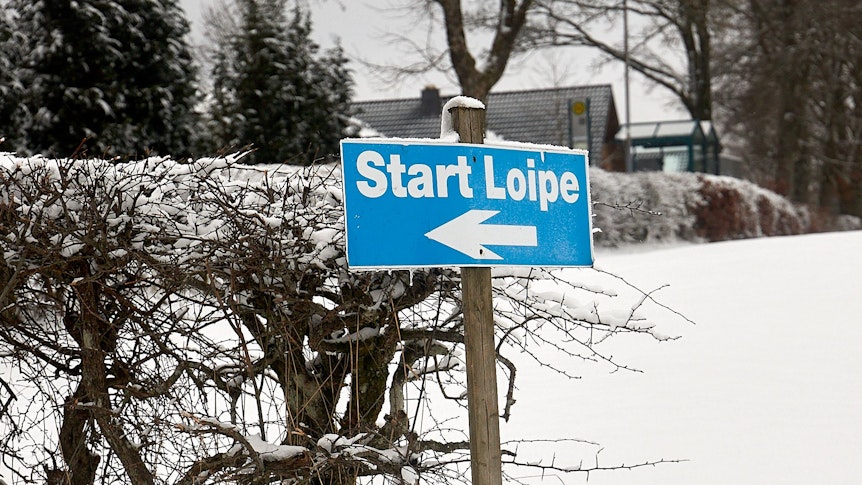 Auf einem blauen Schild steht Start Loipe.