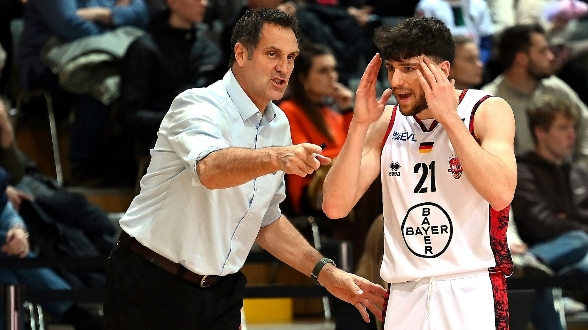 Ein Basketballtrainer gibt seinem Spieler taktische Anweisungen.