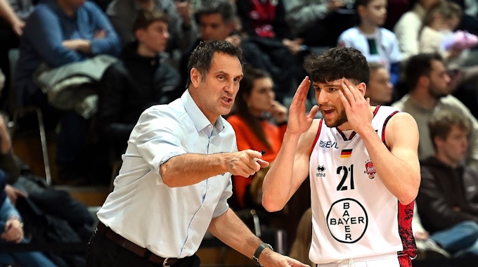 Ein Basketballtrainer gibt seinem Spieler taktische Anweisungen.