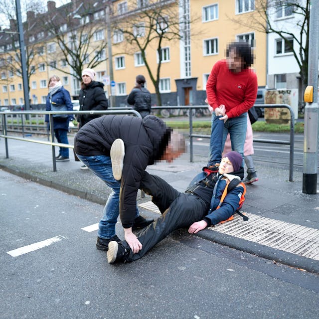 Passanten versuchen, einen Aktivisten der „Letzten Generation“ von der Straße zu tragen.