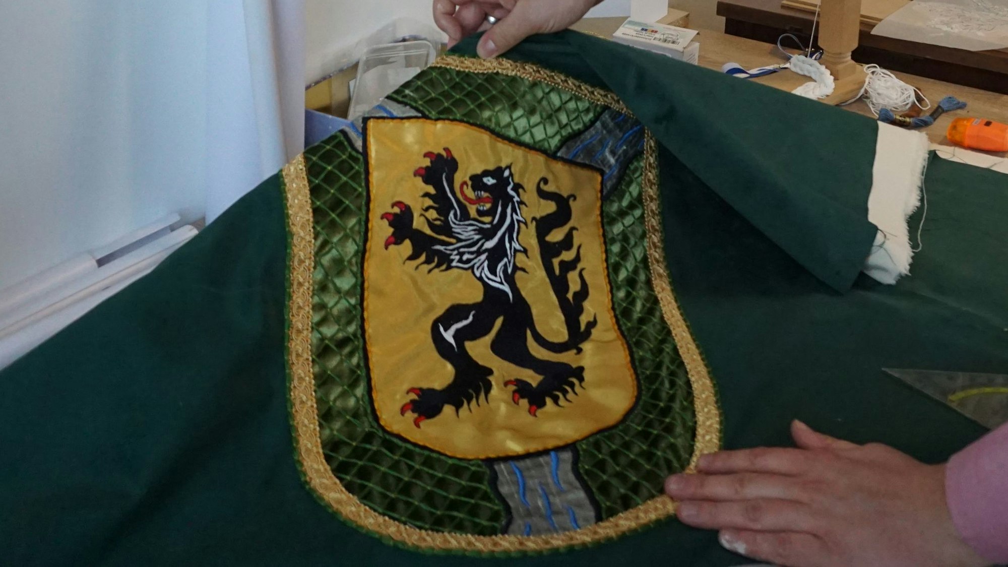 Das Wappen von Gemünd mit einem Löwen ist auf grünem Stoff zu sehen.