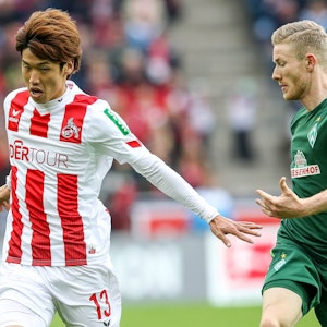 Yuya Osako und Florian Kainz beim Bundesliga-Duell zwischen dem 1. FC Köln und Werder Bremen im Kampf um den Ball.