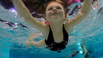 Ein Kind schwimmt in einem Schwimmbecken.