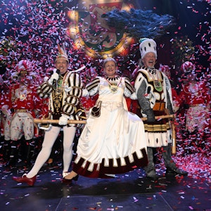 Ein Dreigestirn tanzt in rot-weißem Konfetti-Regen.