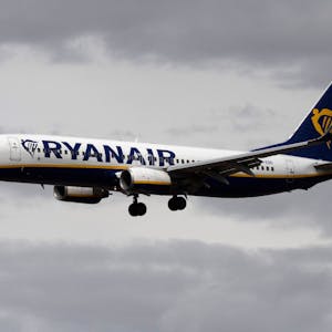 Eine Passagiermaschine von Ryanair setzt vor dunklen Wolken zum Landeanflug an.