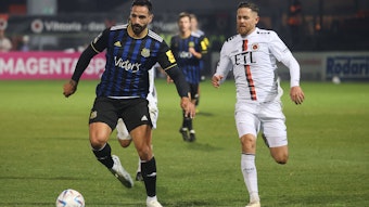 Zwei Fußballer befinden sich im Laufduell, der linke der beiden Spieler führt den Ball.