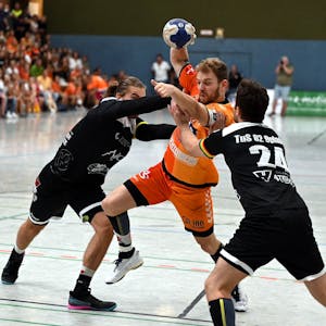 Ein Handballspieler setzt sich gegen zwei Gegner durch.&nbsp;
