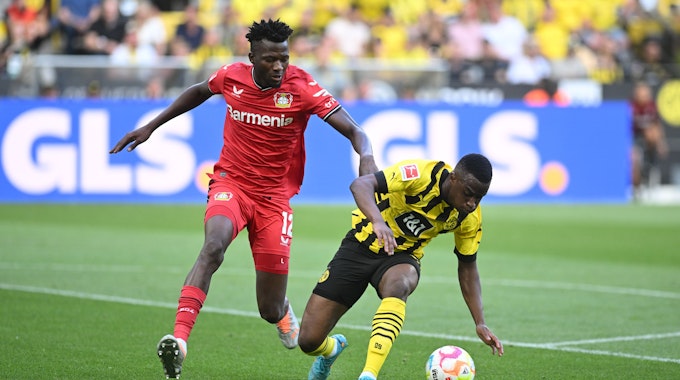 Dortmunds Youssoufa Moukoko (rechts) und Leverkusens Edmond Tapsoba kämpfen um den Ball.