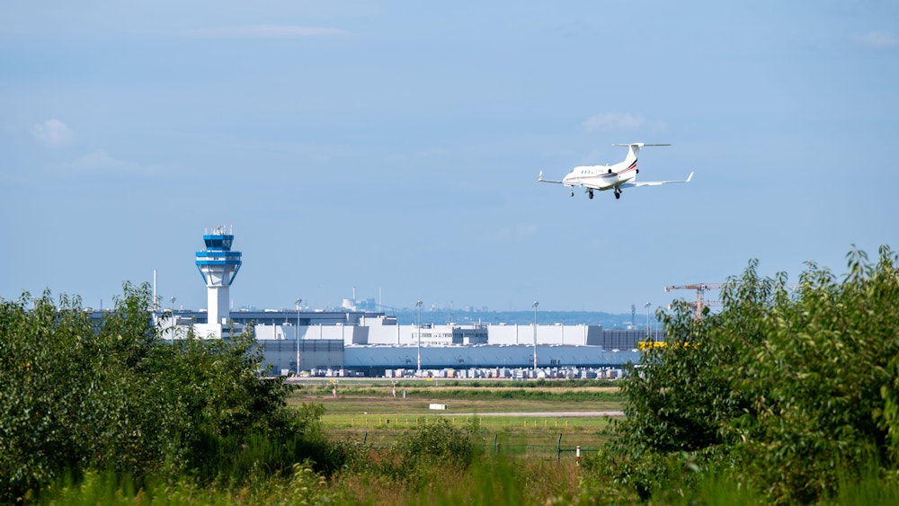 Ein Flugzeug landet auf dem Flughafen Köln/Bonn. Das Rollfeld ist aus der Ferne zu sehen.
