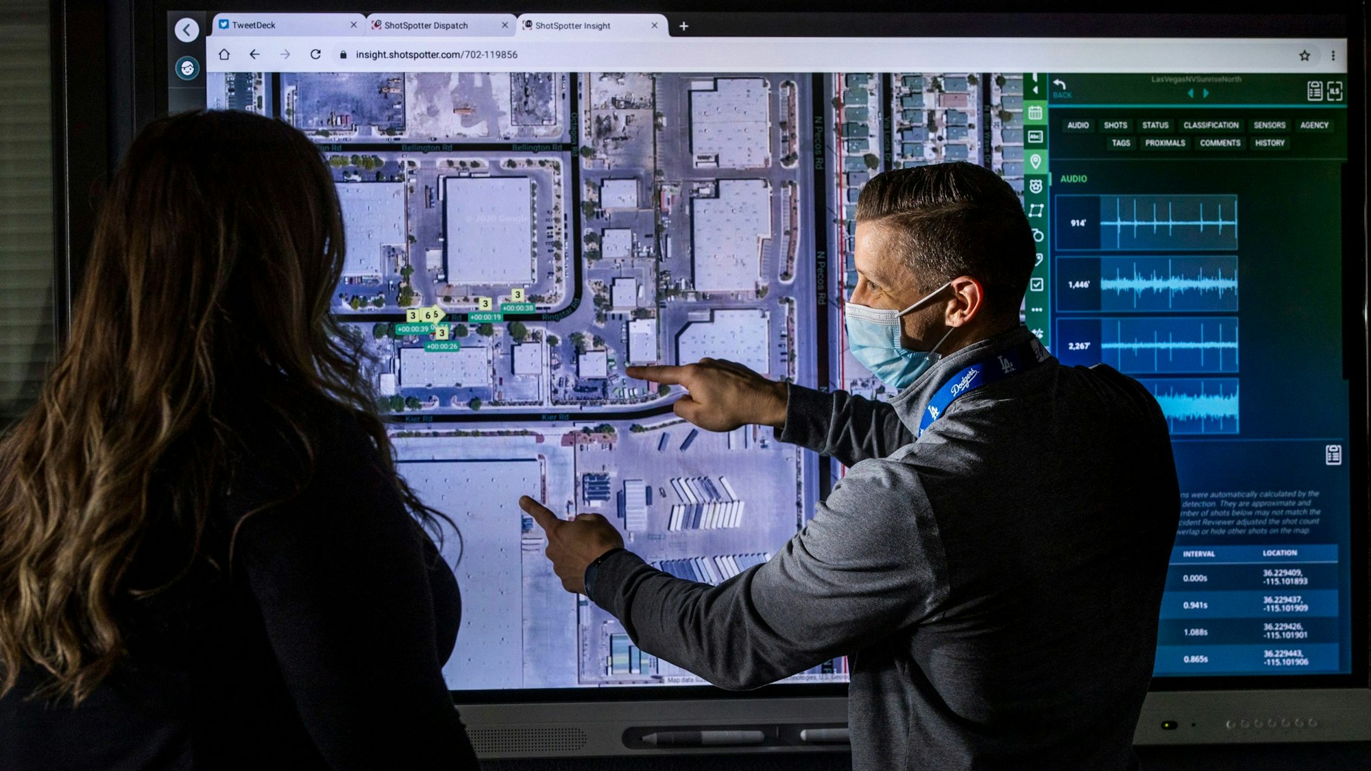 Vor einem großen Monitor mit einer Luftaufnahme von Las Vegas stehen eine Frau und ein Mann. Der Mann deutet auf Stellen auf dem Foto.