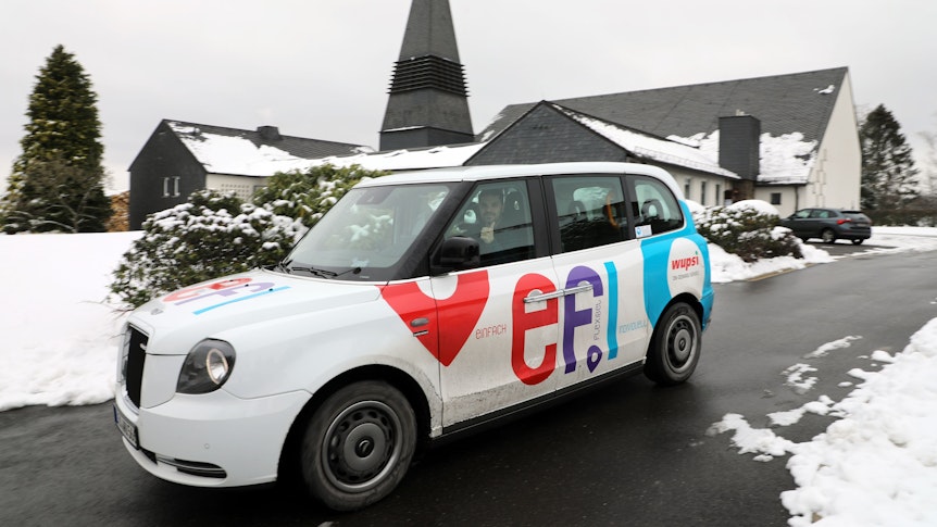 Ein „Efi“-Auf-Abruf-Taxi fährt vor der Neschener Kirche St. Michael an.