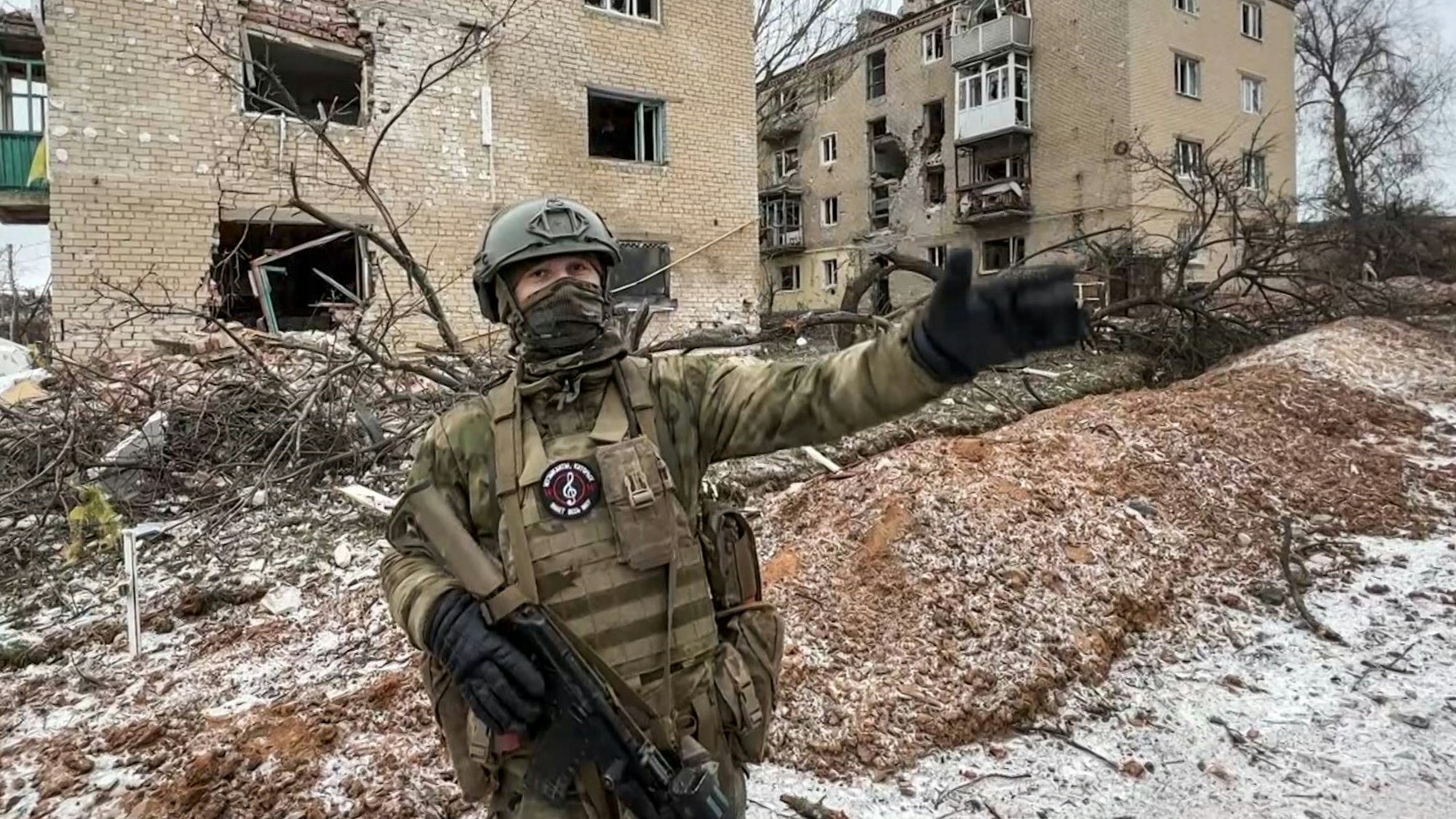 Ein Sölnder der Wagner-Gruppe steht vor einem zerstörten Gebäude in der ukrainischen Stadt Soledar. Die Söldner kommen auf russischer Seite im Krieg gegen die Ukraine zum Einsatz. (Archivbild)