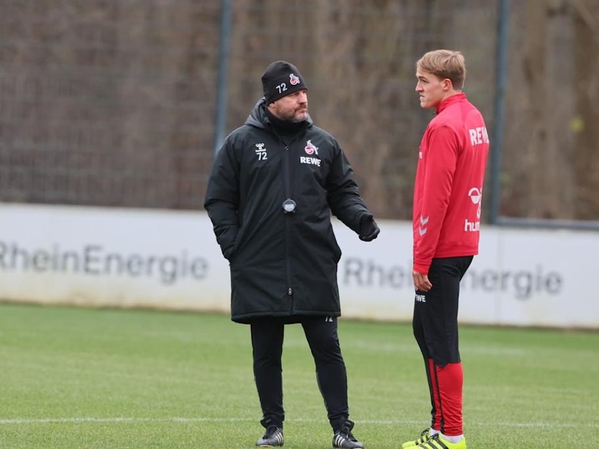 Timo Hübers spricht im Training des 1. FC Köln mit Steffen Baumgart.