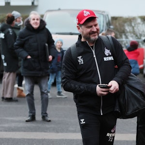 Steffen Baumgart läuft am Geißbockheim grinsend zum Mannschaftsbus.