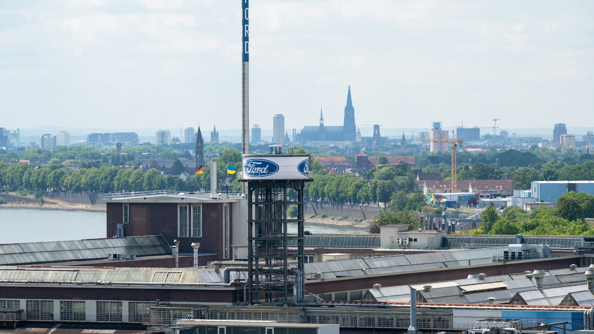Das Bild zeigt das Werksgelände von Ford, im Hintergrund ist die Kölner Skyline zu sehen.