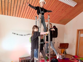 Einige Kinder turnen an zwei Leitern.