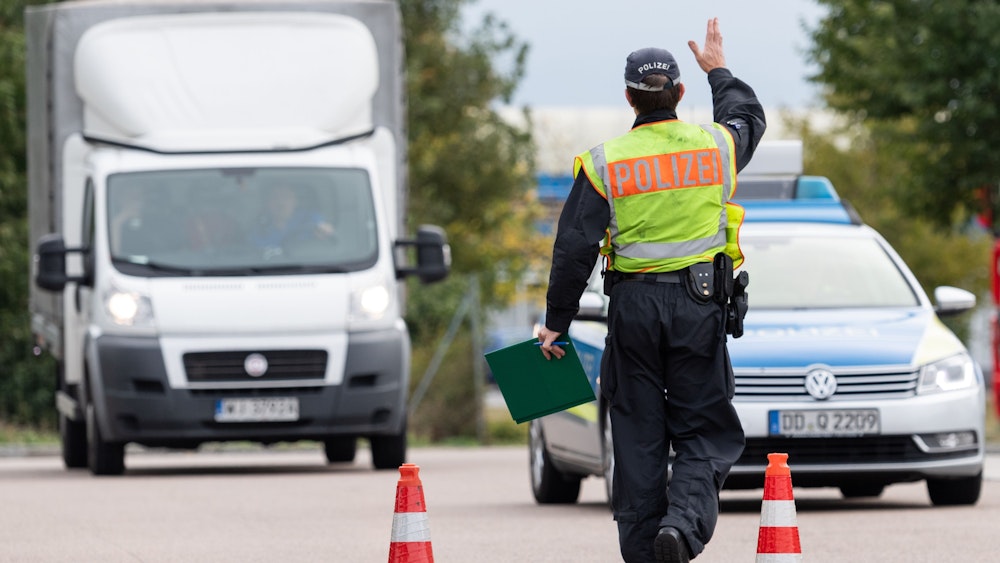 Ein Polizist winkt am Rastplatz Dresdner Tor an der A4 einen Transporter aus Polen zur Kontrolle raus.