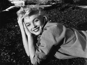 Marilyn Monroe liegend auf der Wiese.