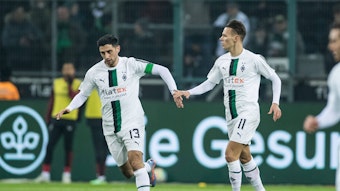 Lars Stindl (l.) und Hannes Wolf klatschen nach dem Treffer von Stindl zum 1:3 im Spiel von Borussia Mönchengladbach gegen Bayer Leverkusen im Laufen ab. Die beiden Gladbach-Spieler tragen das weiße Heimtrikot vom Borussia.