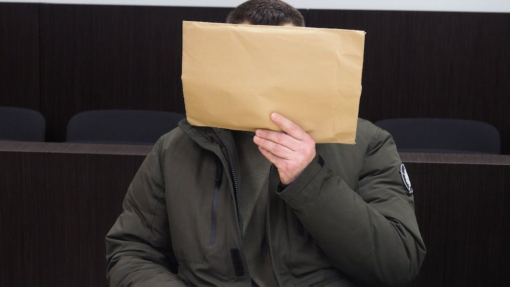 Tim M. gestern im Düs­sel­dor­fer Land­ge­richt. Er verdeckt sein Gesicht mit einem Briefumschlag.