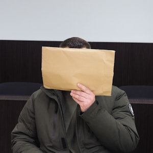 Tim M. gestern im Düsseldorfer Landgericht. Er verdeckt sein Gesicht mit einem Briefumschlag.