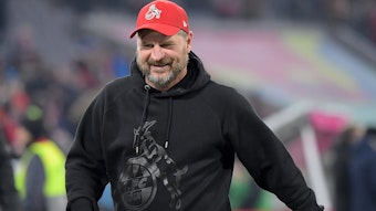 Steffen Baumgart, Trainer des 1. FC Köln, läuft lächelnd am Spielfeldrand entlang.