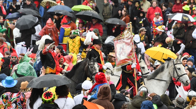 Eine Gruppe zu Pferd reitet beim Rosenmontagszug 2020 in Düsseldorf durch die Menge.