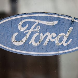 23.01.2023, Nordrhein-Westfalen, Köln: Ein abgeblättertes Logo von Ford hängt an einer Scheibe vor dem Werksgelände. Der Autobauer Ford will an seinem Kölner Standort nach Angaben des Betriebsrats im großen Stil Jobs abbauen.