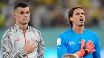 Granit Xhaka (l.) und Yann Sommer stehen vor dem WM-Spiel gegen Brasilien am 28. November 2022 nebeneinander bei der Nationalhymne. Beide Spieler der Schweiz legen ihre rechte Hand auf ihre Brust.