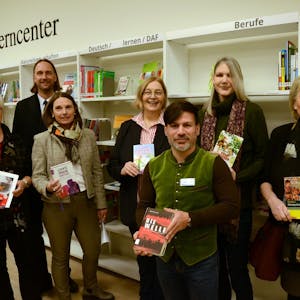 Die Mitarbeiter und Mitarbeiterinnen der Stadtbibliothek Troisdorf halten die Bücher mit Einfacher Sprache in der Hand.