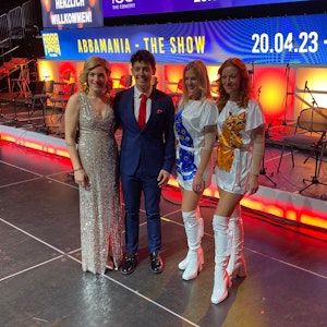 Vier Darstellerinnen und Darsteller der Shows „ABBAMania – The Show“ und „Disney100: The Concert“ auf der Bühne der Lanxess-Arena.