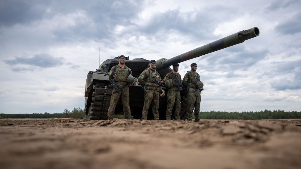 Soldaten stehen vor einem Leopard-2-Panzer der Bundeswehr, der von der NATO Enhanced Forward Presence Battle Group (eFP-Bataillon) eingesetzt wird.