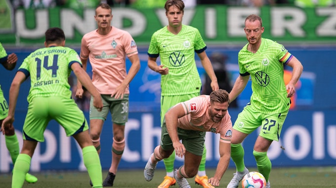 Niclas Füllkrug geht im Spiel von Werder Bremen beim VfL Wolfsburg zu Boden.